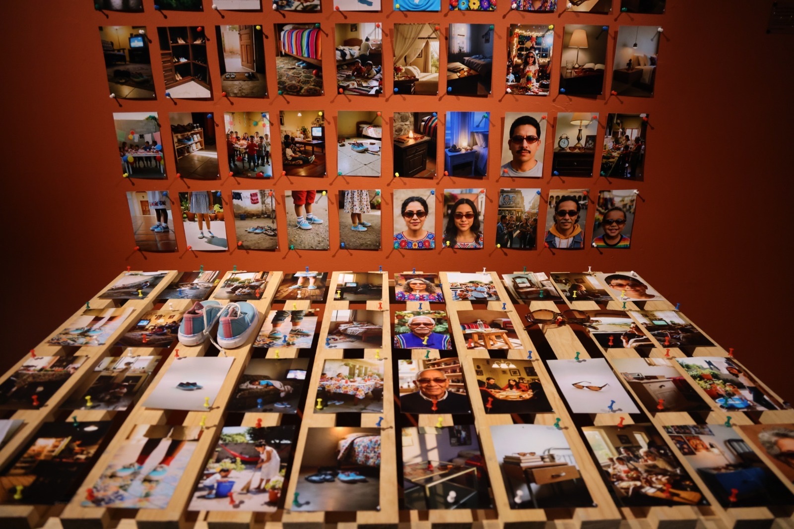 Vista del muro de fotografías y la mesa de madera con los objetos